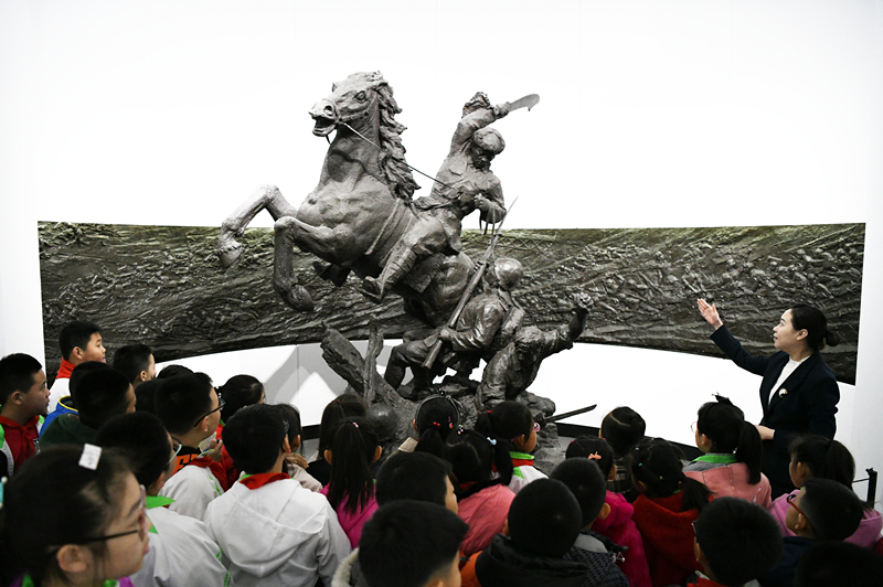 2019年4月4日，在東北烈士紀(jì)念館，學(xué)生們?cè)诼?tīng)講解員講解。